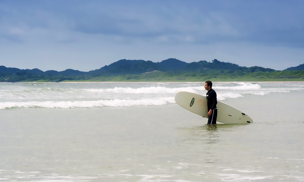Young man going to surf in Tamarindo